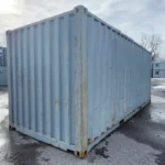 Vue avant du conteneur 20 pieds usagé avec peinture gris pâle