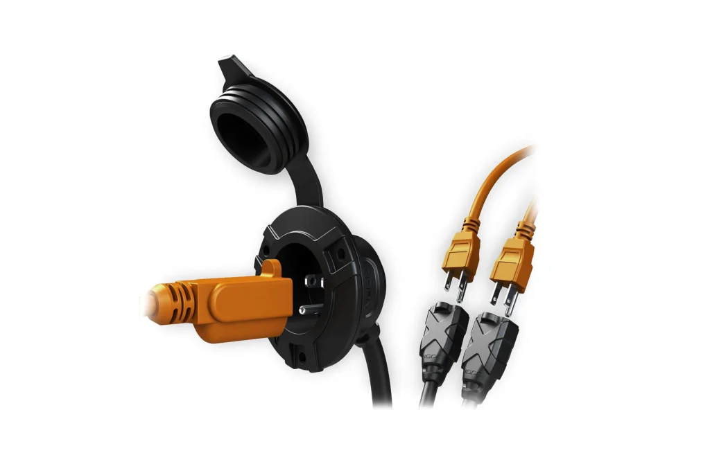 Open NOCO AC inlet power port accepting a standard plug, dual-outlet splitter powering tools inside a shipping container, ATS Containers.