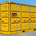 20ft yellow dangerous goods shipping container with ATS branding, ventilation panels, and hazardous material labeling on the exterior.