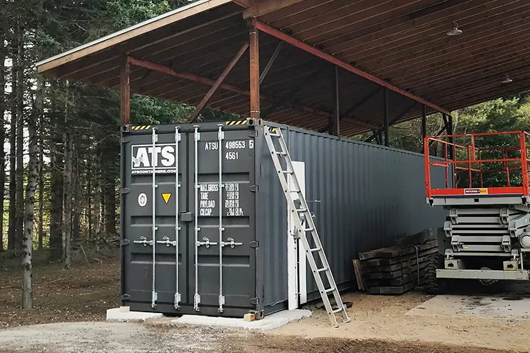 40-ft shipping container for sale, used as secure on-site storage in a parking lot for construction tools and equipment. Special project with container