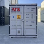 Gros plan sur le mécanisme de verrouillage haute sécurité et le cache-cadenas sur la porte d'un conteneur maritime.