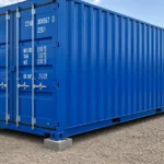Heavy-duty plastic levelling pads placed under multiple points of a shipping container to create a stable, level foundation.