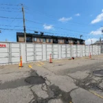 Light grey 40 ft high cube side door shipping container being used on site